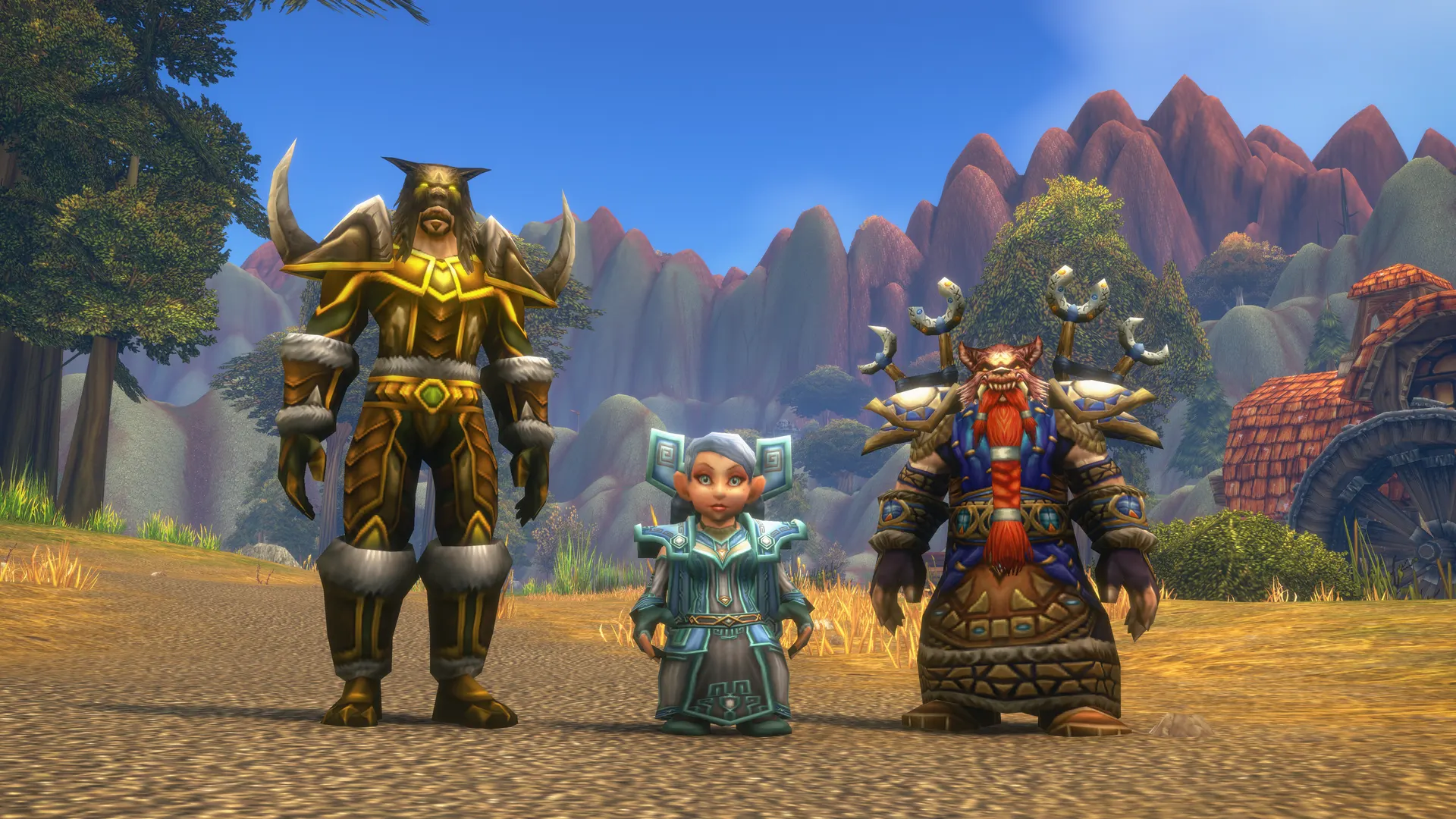 A Tauren, a Gnome and a Dwarf in new class armour, standing in a grassy valley